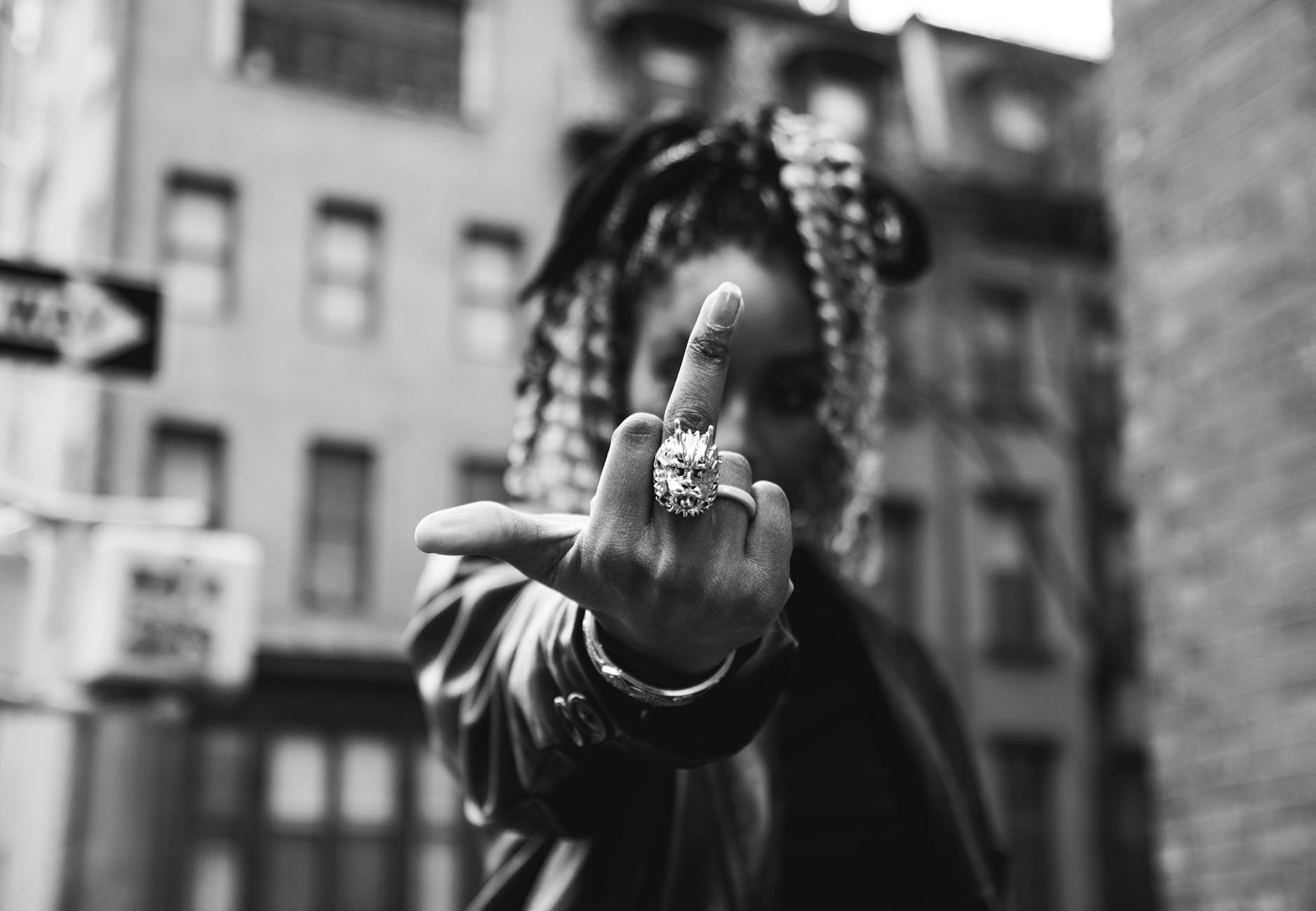 grayscale photo of a person doing bad hand sign