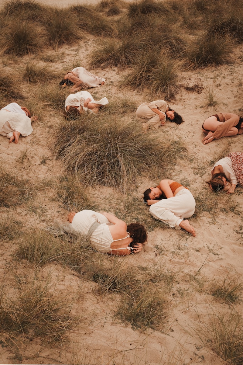 A group of people laying on top of a sandy beach